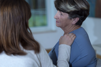 female caregiver comforting senior woman