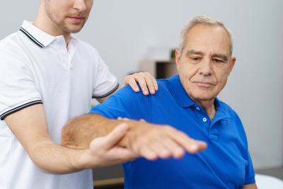 male caregiver giving physical therapy to an elder man