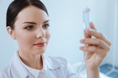 nurse holding drip chamber