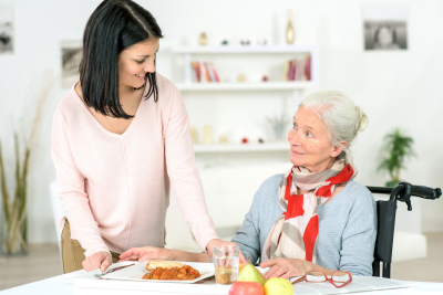 young lady preparing food for an elder woman